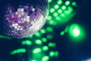 a purple disco ball is hanging from a crowd of lights at The Paddock Wildcamp in Perranporth