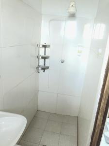 a bathroom with a shower with a toilet and a sink at Bay View Apartment 4 - Canouan Island in Canouan