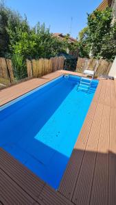 a blue swimming pool with a chair on a wooden deck at B&B In Sabina in Poggio Nativo