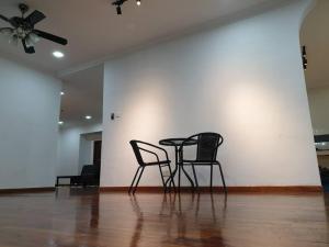 Nilai Spring Villas في نيلاي: كرسيين وطاولة في غرفة ذات سقف