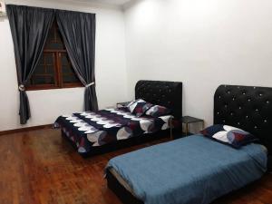 a bedroom with two beds and a window at Nilai Spring Villas in Nilai