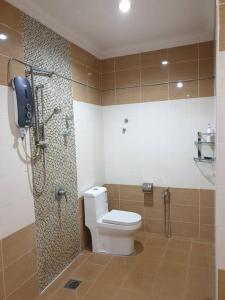 a bathroom with a toilet and a shower with a phone at Nilai Spring Villas in Nilai