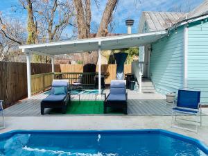 Un patio con dos sillas y una piscina. en Historic home with heated Mini Pool walking distance to downtown San Antonio!, en San Antonio