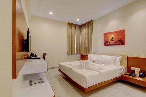 a bedroom with a white bed and a television at MySpace Tattwa Grand in Yelahanka