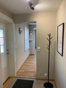 a hallway with white walls and wooden floors and a plant at Fin leilighet, sentralt og sjønært,med parkering in Arendal