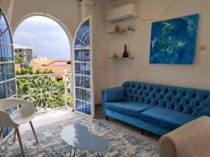 Sofá azul en la sala de estar con ventana en Dolce Vita Palacio, en Douala
