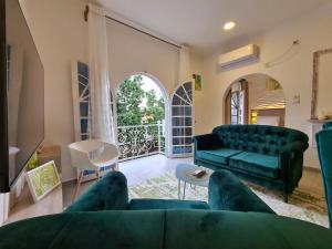 sala de estar con sofá verde y balcón en Dolce Vita Palacio, en Douala