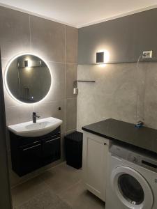a bathroom with a sink and a washing machine at Fin leilighet, sentralt og sjønært,med parkering in Arendal