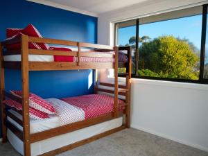 a bunk bed room with two bunk beds and a window at The Beach Escape in Primrose Sands