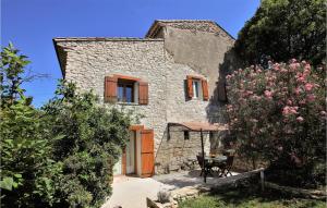 uma casa de pedra com uma mesa e um pátio em 2 Bedroom Beautiful Home In St Didier em Saint-Didier