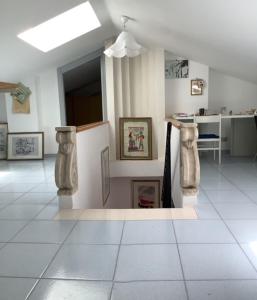 Habitación con estatuas en las paredes y suelo de baldosa blanca. en A great house,food&good wine with a tour in Matera, en Barile