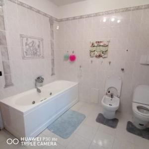 bagno bianco con vasca e servizi igienici di Il casale dell'artista a Laino Borgo