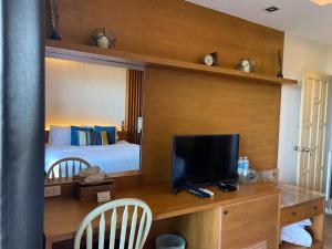 a bedroom with a bed and a desk with a television at Phuket View Coffee and Resort in Chalong