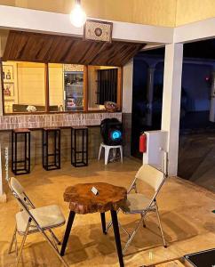 una cucina con tavolo, sedie e bar di RESIDENCE AINA ad Abomey-Calavi
