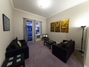 een woonkamer met 2 banken en een tafel bij Mansions on Pulteney in Adelaide