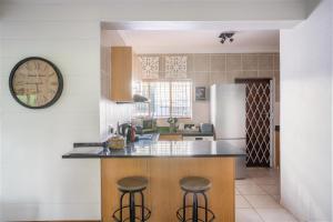 a kitchen with a counter and a clock on the wall at Avemore Wag n Bietjie No 1 in Stellenbosch