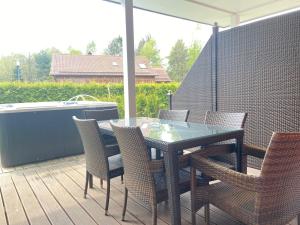 einen Glastisch und Stühle auf einer Terrasse mit einer Badewanne in der Unterkunft Reiger Ferienwohnungen in Wackersdorf