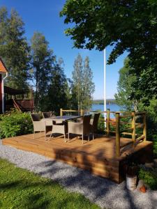 une terrasse en bois avec une table et des chaises dans l'établissement Det lilla huset, à Nora