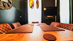 einem Holztisch mit Stühlen und einem großen Holztisch sidx sidx in der Unterkunft Vienna CityApartments - Premium 6 in Wien