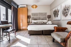 um quarto com uma cama, uma mesa e cadeiras em Avemore Eikehof No 24 em Stellenbosch