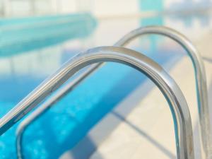 a metal railing next to a swimming pool at SITARA HOTEL APARTMENT in Dubai