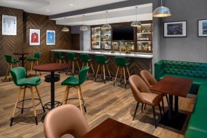 um bar com cadeiras verdes e mesas num restaurante em Holiday Inn Express Dubai Internet City, an IHG Hotel em Dubai