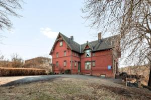 ein großes rotes Backsteinhaus mit schwarzem Dach in der Unterkunft Villa Internationals Residence in Oslo