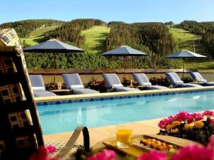 a pool with lounge chairs and a table with a drink at Platinum 2 Bedroom Vacation Rental In The Heart Of Vail That Includes Ski Valet, Ski Deck, Rooftop Pool, Panoramic Views in Vail +12 photos