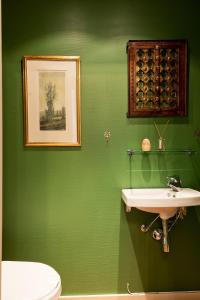 a green bathroom with a sink and a toilet at Villa Internationals Residence in Oslo