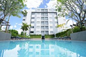 un hotel con piscina di fronte a un edificio di NOON Village - Tower 2&3 a Chalong