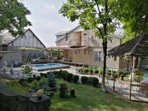a house with a garden and a swimming pool at Family Hotel Lago & Wine Cellar in Lagodekhi