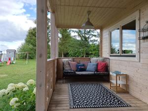 a screened porch with a couch on a patio at Na Miedzy in Dźwierzuty