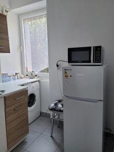 uma cozinha com um micro-ondas em cima de um frigorífico em Apartament City Center em Lańcut