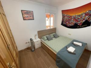 mała sypialnia z łóżkiem i oknem w obiekcie Sunny 3 bed apartment only 7 minute walk from beac w mieście La Herradura +4 zdjęcia