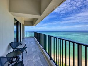 Un balcón con sillas y vistas al océano. en Ryukyu Hotel & Resort Nashiro Beach en Itoman