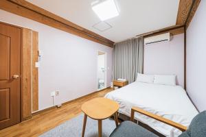 a bedroom with a bed and a table and a chair at Jeju Miju Hotel in Jeju