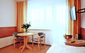 a room with a table and two chairs and a window at SP ZOZ Sanatorium Uzdrowiskowe MSWiA w Kołobrzegu in Kołobrzeg