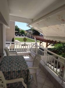 - une terrasse couverte avec une table, des chaises et un parasol dans l'établissement Helena's Apartment 2 Agia Triada, à Thessalonique