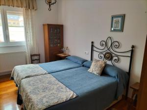 1 dormitorio con 2 camas y ventana en El Pinar, en Ribadeo