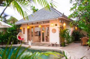 une petite maison avec une piscine en face de celle-ci dans l'établissement Ambermoon Villas, à Seminyak