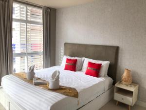 查汶的住宿－Lenny's Koh Samui，一间卧室配有一张带红色枕头的大床和窗户