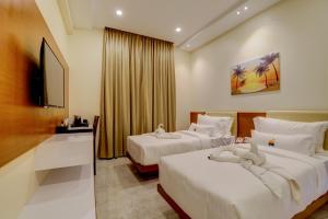 YelahankaにあるTattwa Grandのベッド2台とテレビがあるホテルの部屋 +81枚の写真