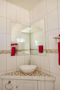 ein Bad mit einem Waschbecken und einem Spiegel in der Unterkunft Elegant 2-bedroom apartment 2 km from Eagle beach in Palm-Eagle Beach