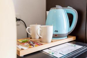 a tea kettle and two cups on a wooden shelf at Kumru Hotel in Istanbul