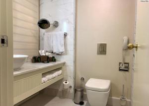 Baño blanco con aseo y lavamanos en MEDWORLD Health & Rehabilitation Center Rixos Antalya en Antalya