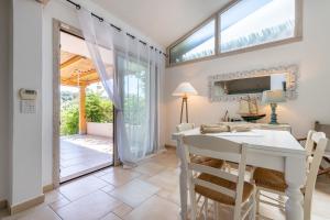 a dining room with a white table and chairs at Casa Vacanza Il Bouganville in Villasimius