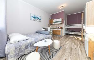 ein kleines Schlafzimmer mit einem Bett und einem Tisch in der Unterkunft Awesome Apartment In Kastel Luksic With Kitchen in Kaštela