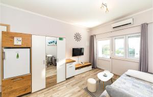 ein Wohnzimmer mit einem Sofa und einem TV in der Unterkunft Awesome Apartment In Kastel Luksic With Kitchen in Kaštela