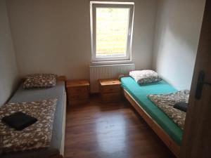una piccola stanza con due letti e una finestra di NA ČERVENE LOUCE relax-LIBA 5 a Libá