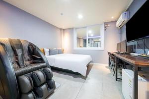 光阳Java Hotel的一间卧室配有一张床和一张带电脑的书桌